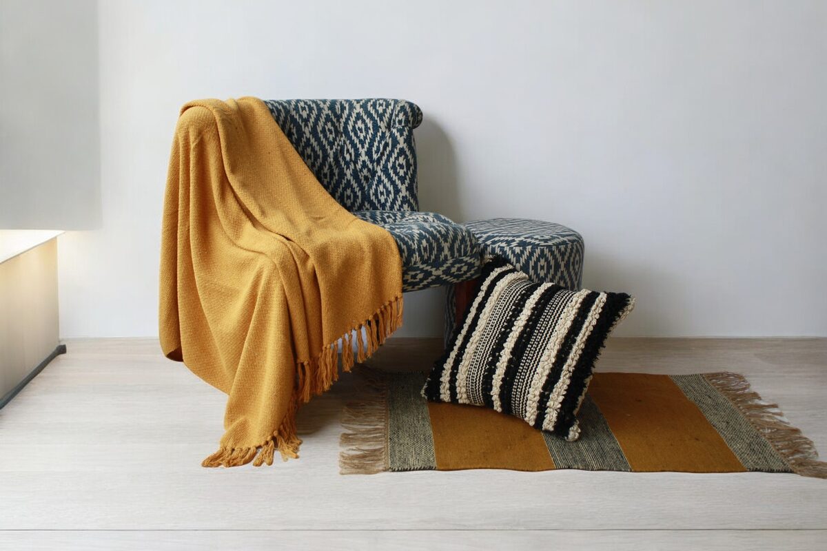 Mustard throw draped on a grey patterned chair