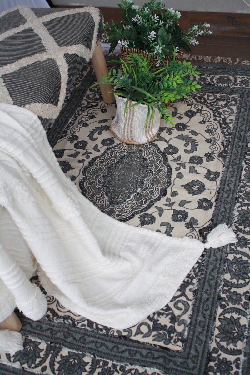 White throw draped over a tufted pouf