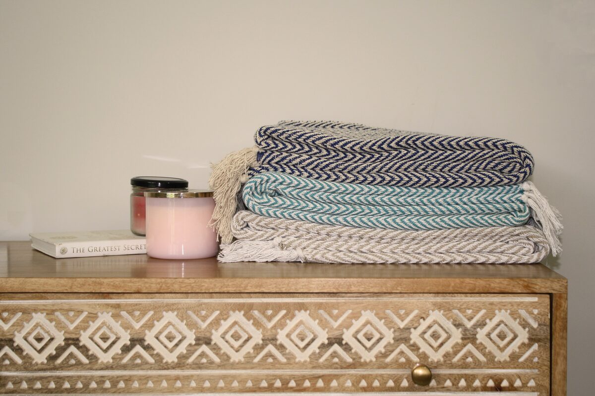 Folded throws stacked on a carved bench