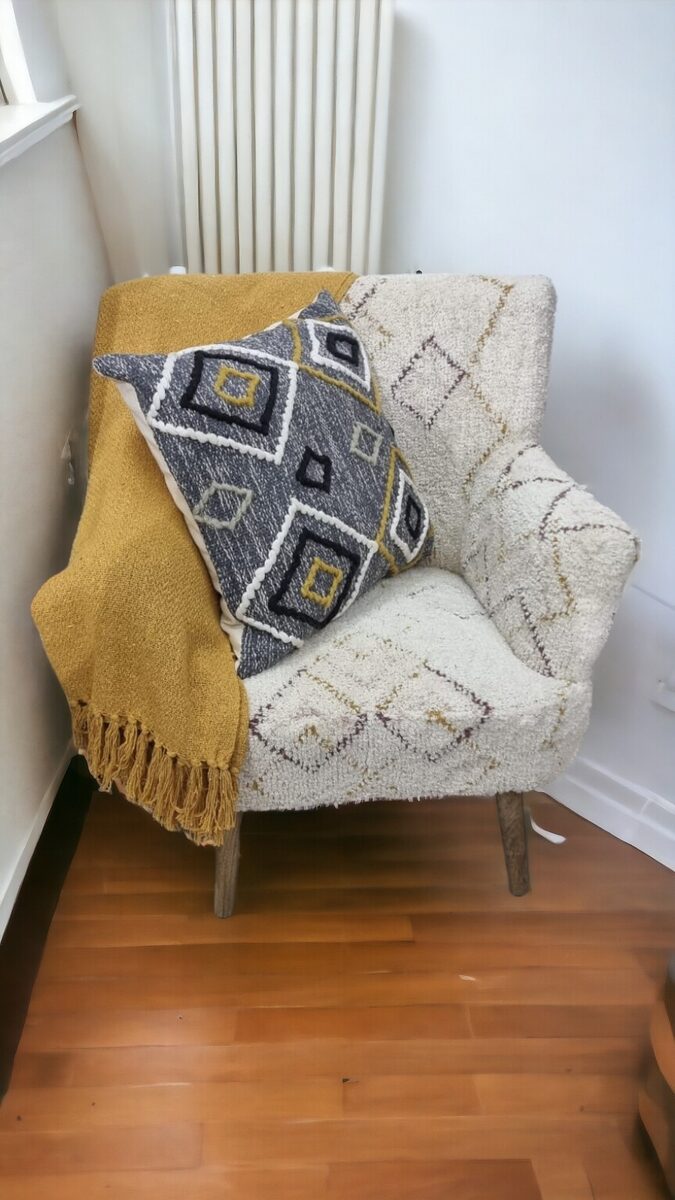 Upholstered armchair with a throw and cushion
