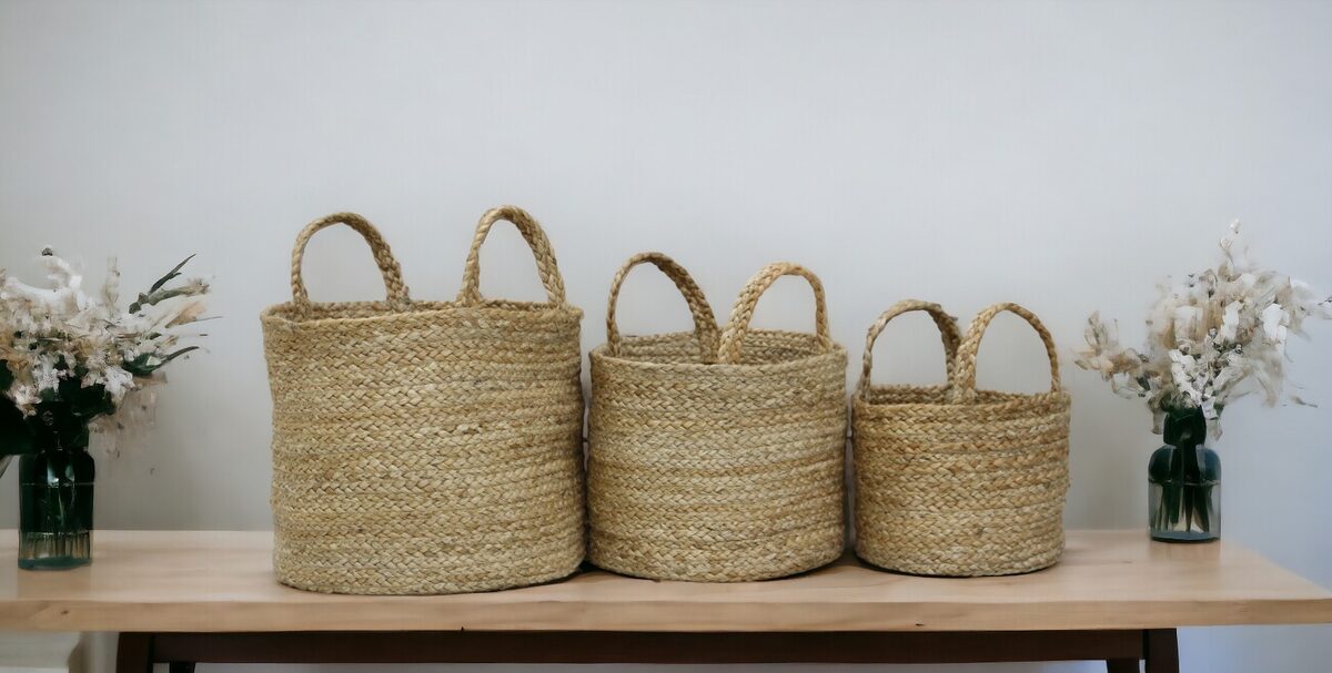 Set of three woven jute planters on a wooden table