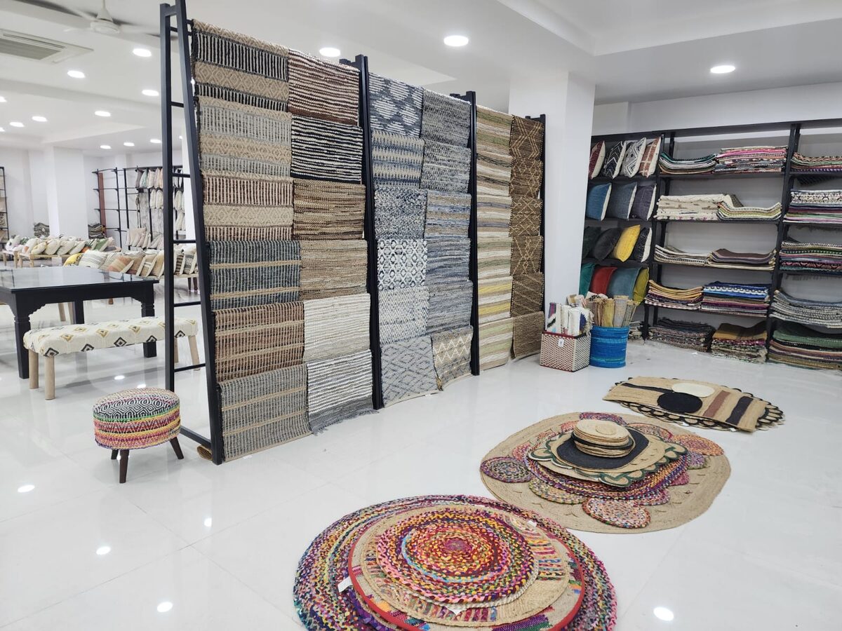 Rug display racks and round braided rugs in the showroom