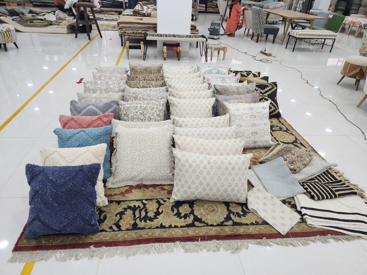 Table of white cushions on a rug in the showroom